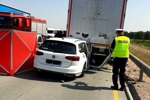 policjant przy pojeździe biorącym udział w zdarzeniach