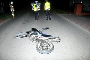 motorower biorący udział w zdarzeniu na drodze, w tle policjanci