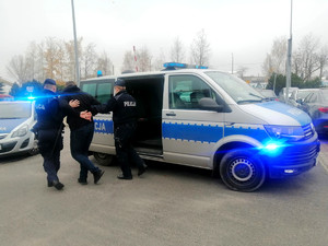 policjanci prowadzą zatrzymanego podczas ćwiczenia pozorującego sytuację kryzysową w Areszcie Śledczym