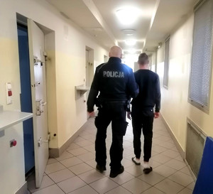 Policjant prowadzi zatrzymanego