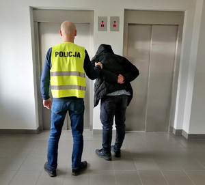 policjant prowadzi zatrzymanego