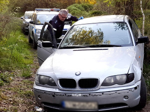 policjant wykonujący czynności w pojeździe bmw