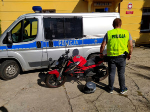 Policjant z odzyskanym motorowerem.