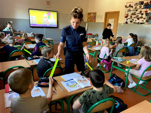 Policjantka wraz z dziećmi w sali lekcyjnej.