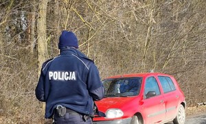 Policjant stojący przy pojeździe nietrzeźwego kierowcy.