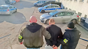 Policjanci prowadzą zatrzymanego.