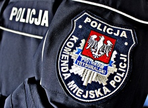 Naszywka na policyjnym mundurze z logiem jednostki i napisem Komenda Miejska Policji w Piotrkowie Trybunalskim.