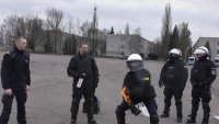 policjant w stroju ochrony indywidualnej i kasku ochronnym trenuje samogaszenie lewej kończyny górnej