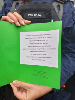 policjant trzyma kartkę z życzeniami