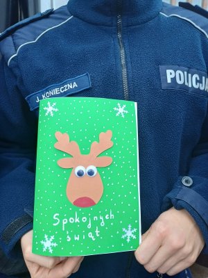 policjant trzyma kartkę z życzeniami