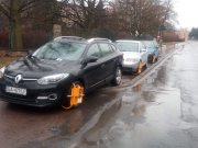 Na zdjęciu widzimy kilka źle zaparkowanych samochodów, które mają na kołach założone blokady.