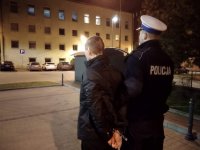 Zatrzymanego sprawcę prowadzi policjant ruchu drogowego