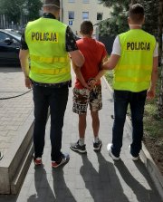 Policjanci prowadzą młodszego z  braci, zatrzymanego  za posiadanie narkotyków