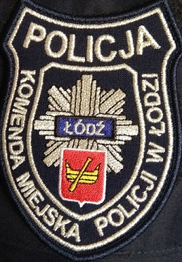 Naszywka policyjna na mundur,  z Herbem Łodzi na tle odznaki policyjnej oraz napisem POLICJA Komenda Miejska Policji w Łodzi
