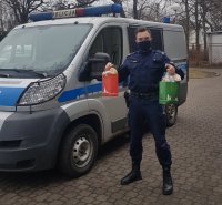 Na zdjęciu widoczny policjant w mundurze trzymający w ręku dwie torby z prezentami.