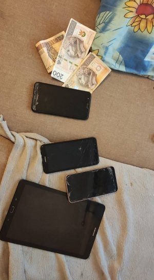 Zabezpieczone telefony i pieniądze na stoliku.