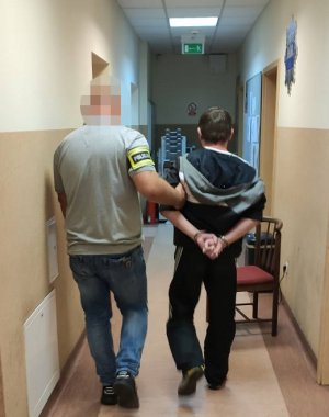 Policjant prowadzi podejrzanego