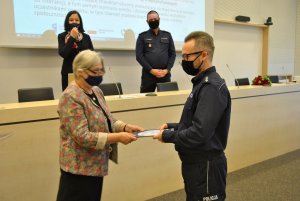 Dziekan Wydziału Filologicznego Uniwersytetu Łódzkiego wręcza policjantowi dyplom ukończenia kursu.