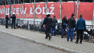 Policjanci nadzorują wejście na stadion kibiców przyjezdnych.