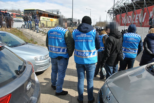 Policjanci z zespołu anty konfliktowego obserwują wejście na stadion kibiców przyjezdnych.