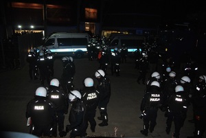 Policjanci zgrupowani przed wejściem na stadion, po zakończonym meczu.