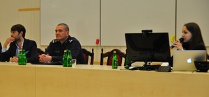 Prelegenci siedzący przy stole: Komendant Miejski Policji w Łodzi, Wiceprezydent Łodzi oraz tłumacz języka ukraińskiego.
