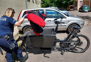 Policjantka sprawdza zawartość gondoli roweru.