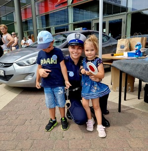policjantka stoi z małymi dziećmi