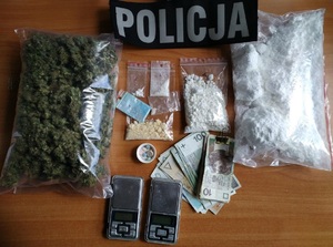 Zdjęcie przedstawia różne narkotyki oraz zabezpieczone telefony komórkowe, wagi elektroniczne oraz pieniądze.