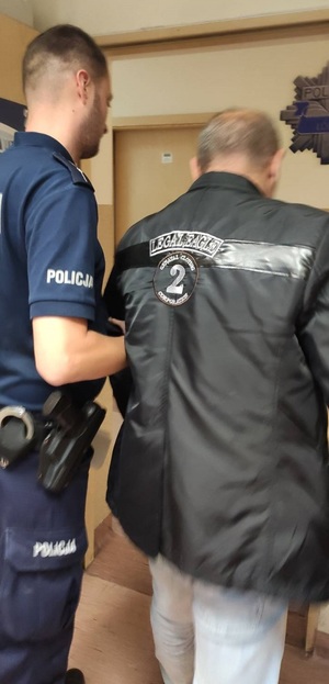 Zatrzymany prowadzony przez policjanta.