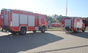 Wozy Państwowej Straży Pożarnej wjeżdżające na teren lotniska.