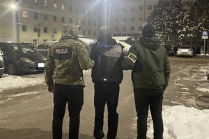Policjanci z zatrzymanym na dziedzińcu Komendy miejskiej Policji w Łodzi.