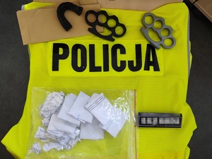 Zabezpieczone narkotyki i kastety leżą na kamizelce z napisem POLICJA