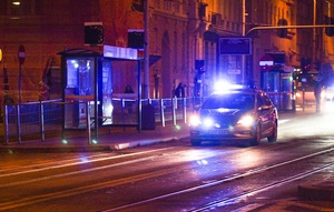 Radiowóz na sygnałach jadący ulicą w nocy.
