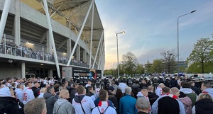 Grupy kibiców kierujące się w stronę wejścia na stadion.