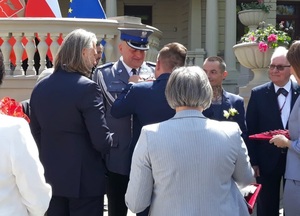 Przewodniczący Rady Miejskiej Marcin Gołaszewski przypina do munduru wyróżnionego policjanta odznakę.