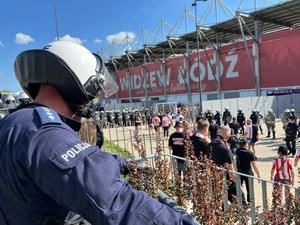 Policjant obserwujący wejście kibiców Cracovii.