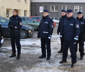 Kierownictwo wraz z oficerem prasowych stoją na dziedzińcu łódzkiej komendy.