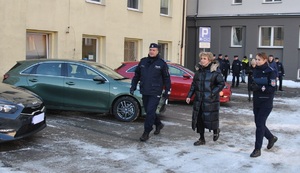 Komendant Miejski Policji w Łodzi wraz z Prezydent Miasta Łodzi w towarzystwie oficera prasowego łódzkiej komendy idą przez dziedziniec.