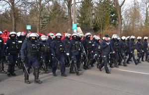 Policjanci zabezpieczają przemarsz kibiców, na czele Pierwszy Zastępca Komendanta Miejskiego Policji w Łodzi nadkomisarz Wojciech Malarczyk.