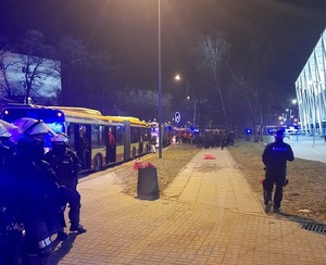 Policjanci w zabezpieczają autobusy komunikacji miejskiej z kibicami gości po meczu.