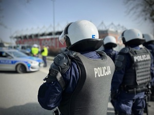 Policjanci podczas zabezpieczenia meczu piłkarskiego na tle stadiony Widzewa Łódź.