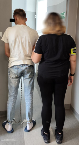 Zatrzymany prowadzony przez policjantkę.