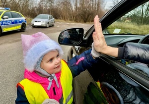 Kierująca przybija piątkę z dziewczynką w zamian za otrzymany prezent.