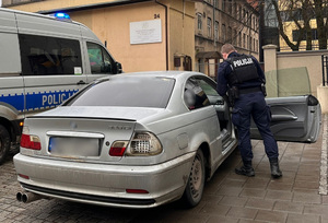 Policjant kontroluje zatrzymany pojazd.