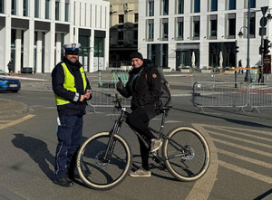 Policjant Wydziału Ruchu Drogowego podczas kontroli rowerzysty.