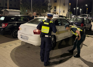 Funkcjonariusz Policji i Służby Celno - Skarbowej w trakcie kontroli pojazdu.