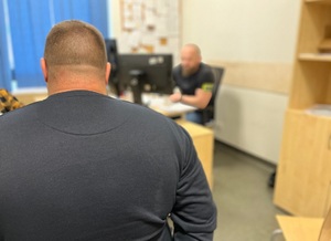 Policjant przesłuchuje zatrzymanego mężczyznę.