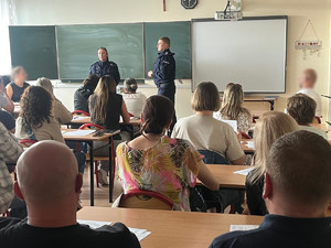 Policjanci w sali zajęć w trakcie rozmowy z rodzicami.