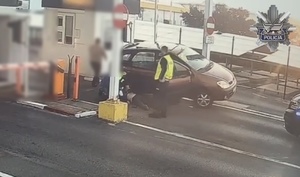 Policjanci udzielają pierwszej pomocy poszkodowanemu w zdarzeniu drogowym.